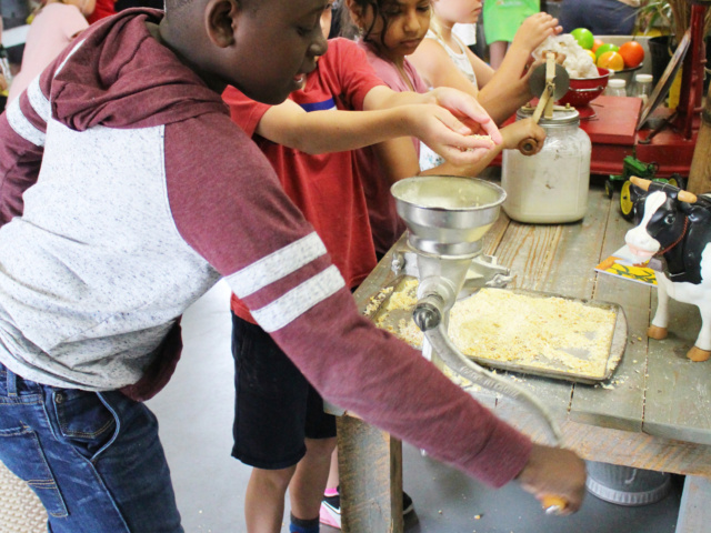 Student Grinding Corn