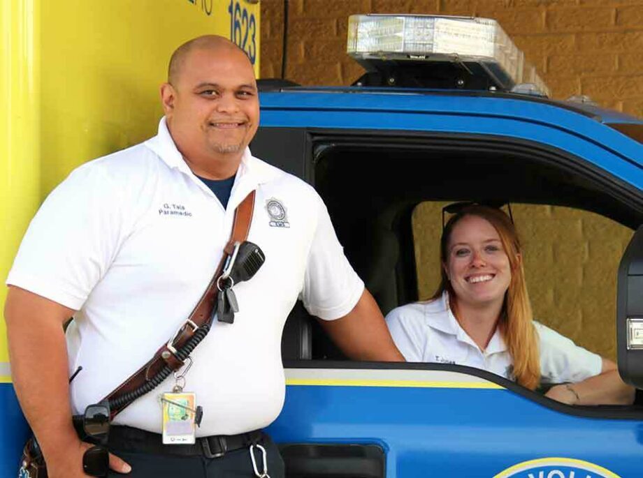 Two paramedics one siting in a car