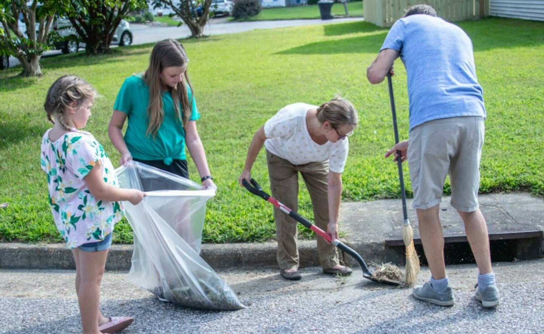 Family cleaning gutter area around drain