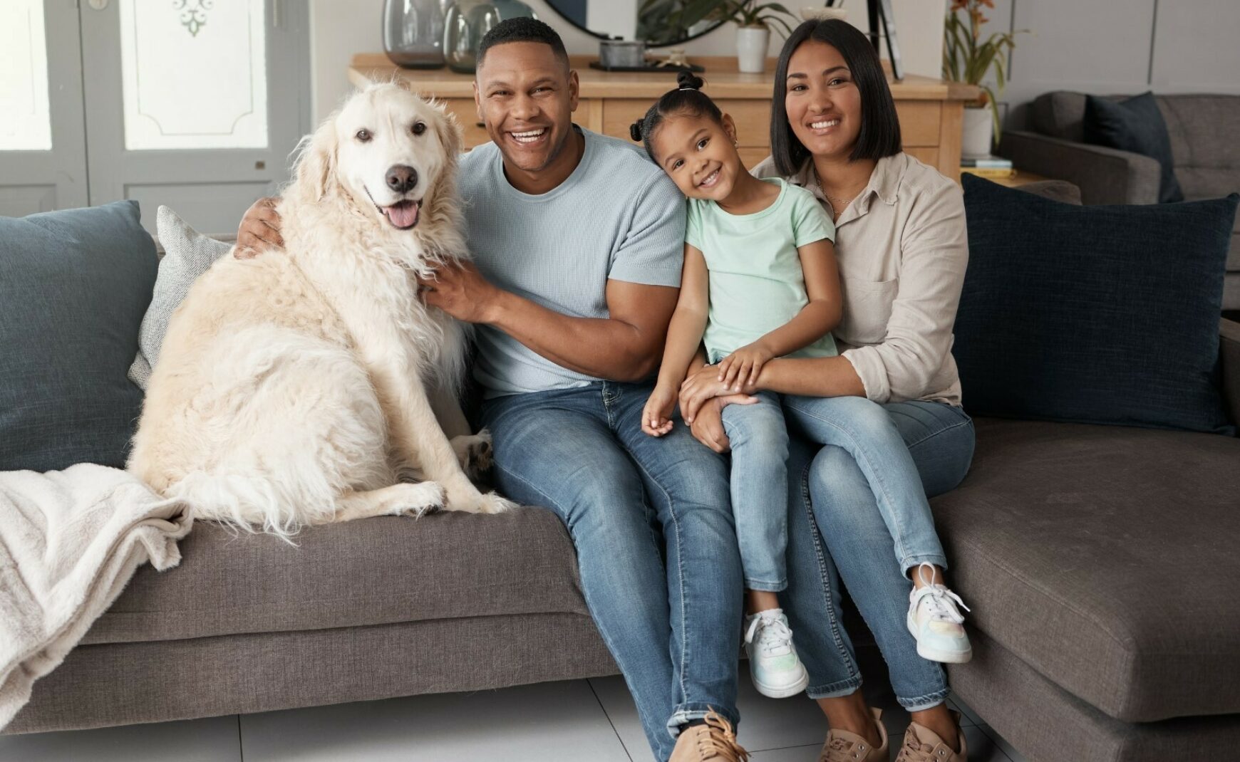 Family sitting on couch with pet dog