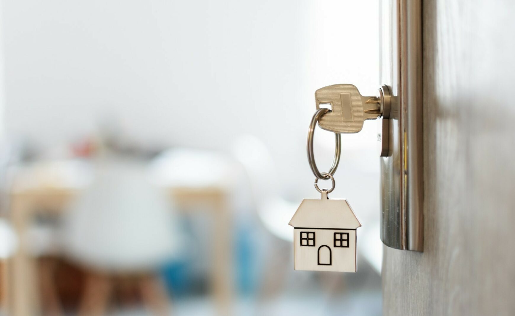 Key with house keychain inserted in door lock