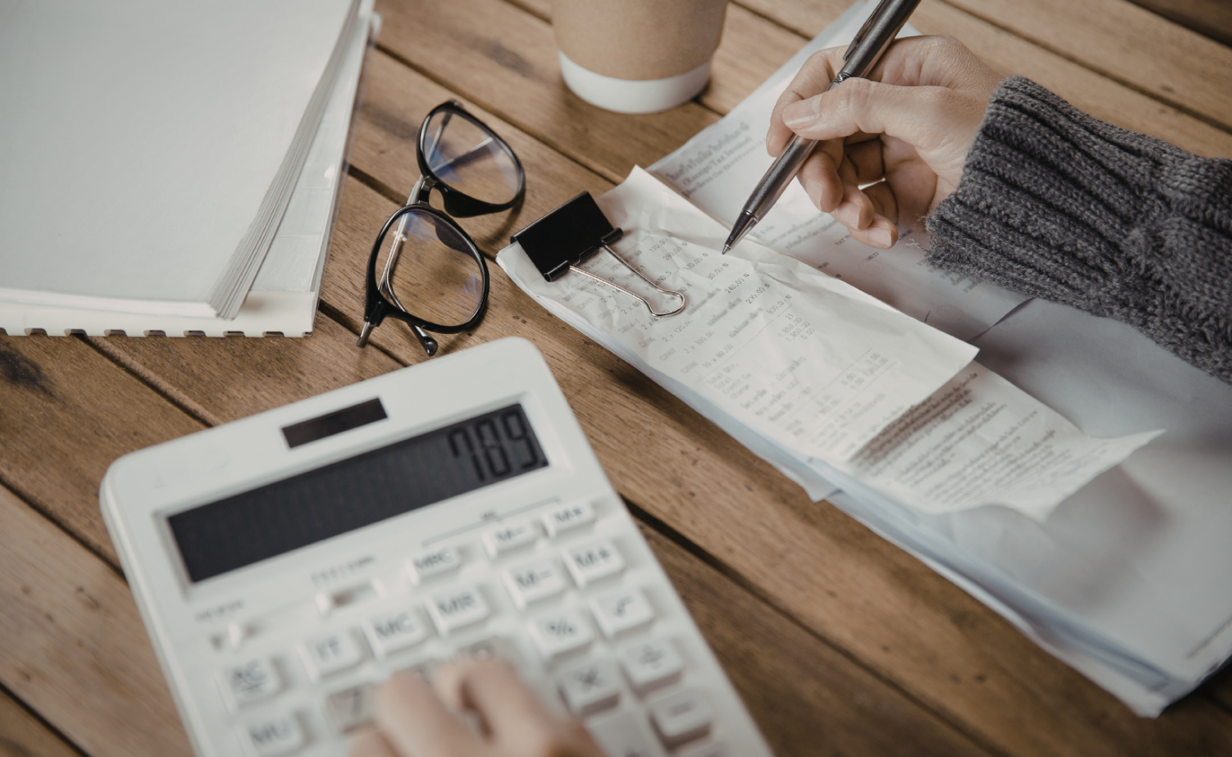 Personal using calculator and looking at receipts