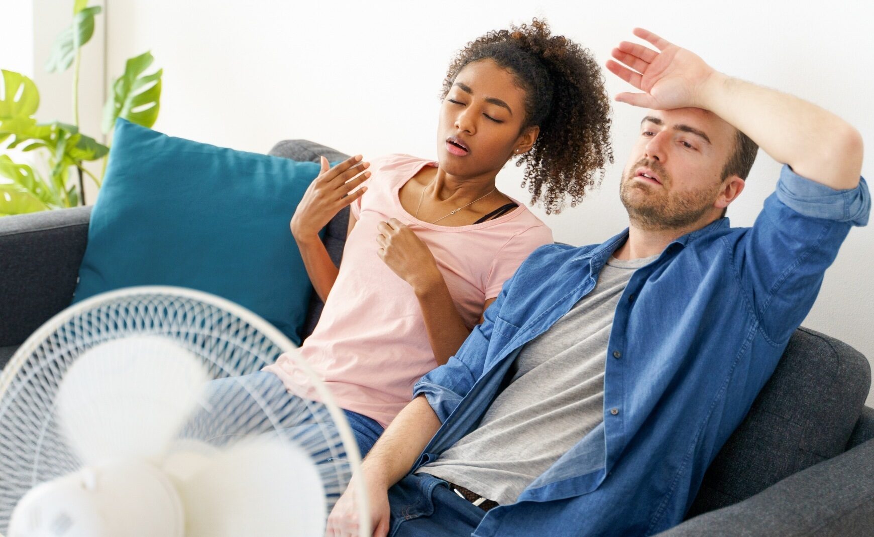Couple using fan to cool down