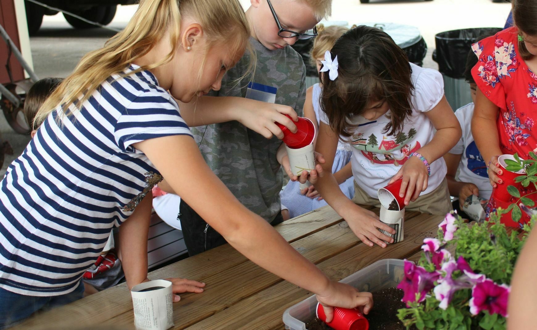 Kids at the farmers market potting soil in containers