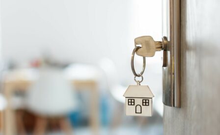 Key with house keychain inserted in door lock