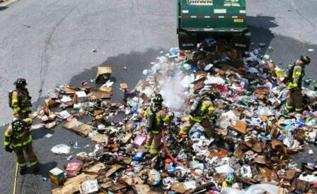 Firefighters putting out fire from waste in truck