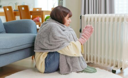 Girl keeping warm in front of space heater