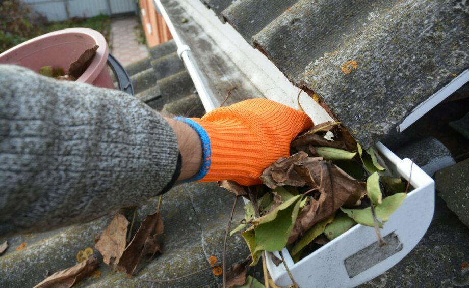 Clearing leaves from rain gutters
