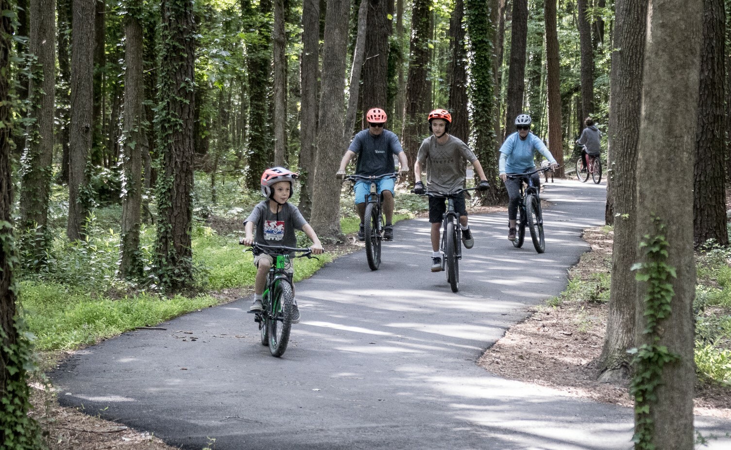 Family riding bikes on trail at Marshview Park