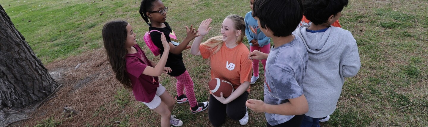Parks and Rec employee high fiving group of kids