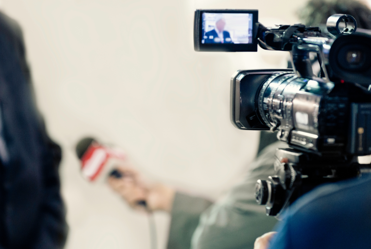 News camera pointed at reporter conducting interview