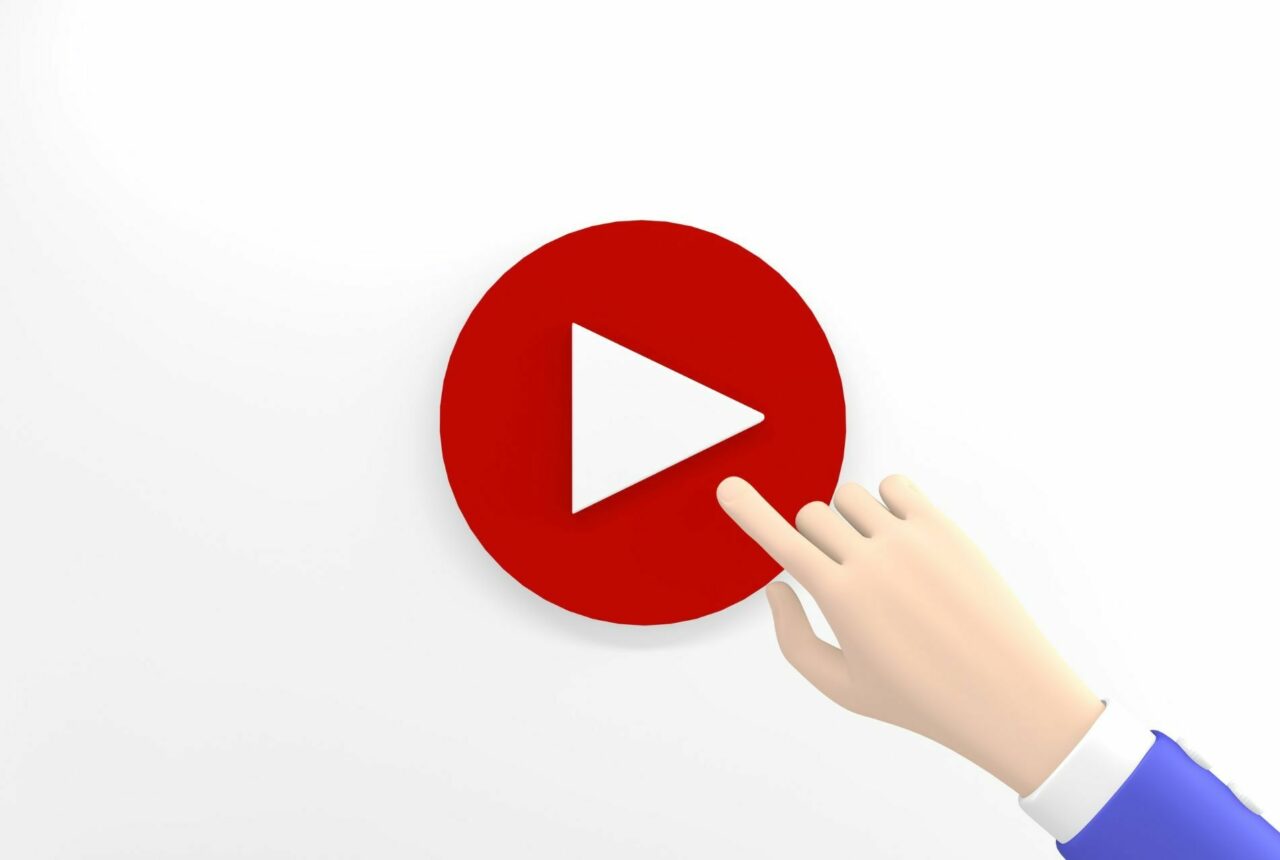 Red play button with rendering of hand pressing button