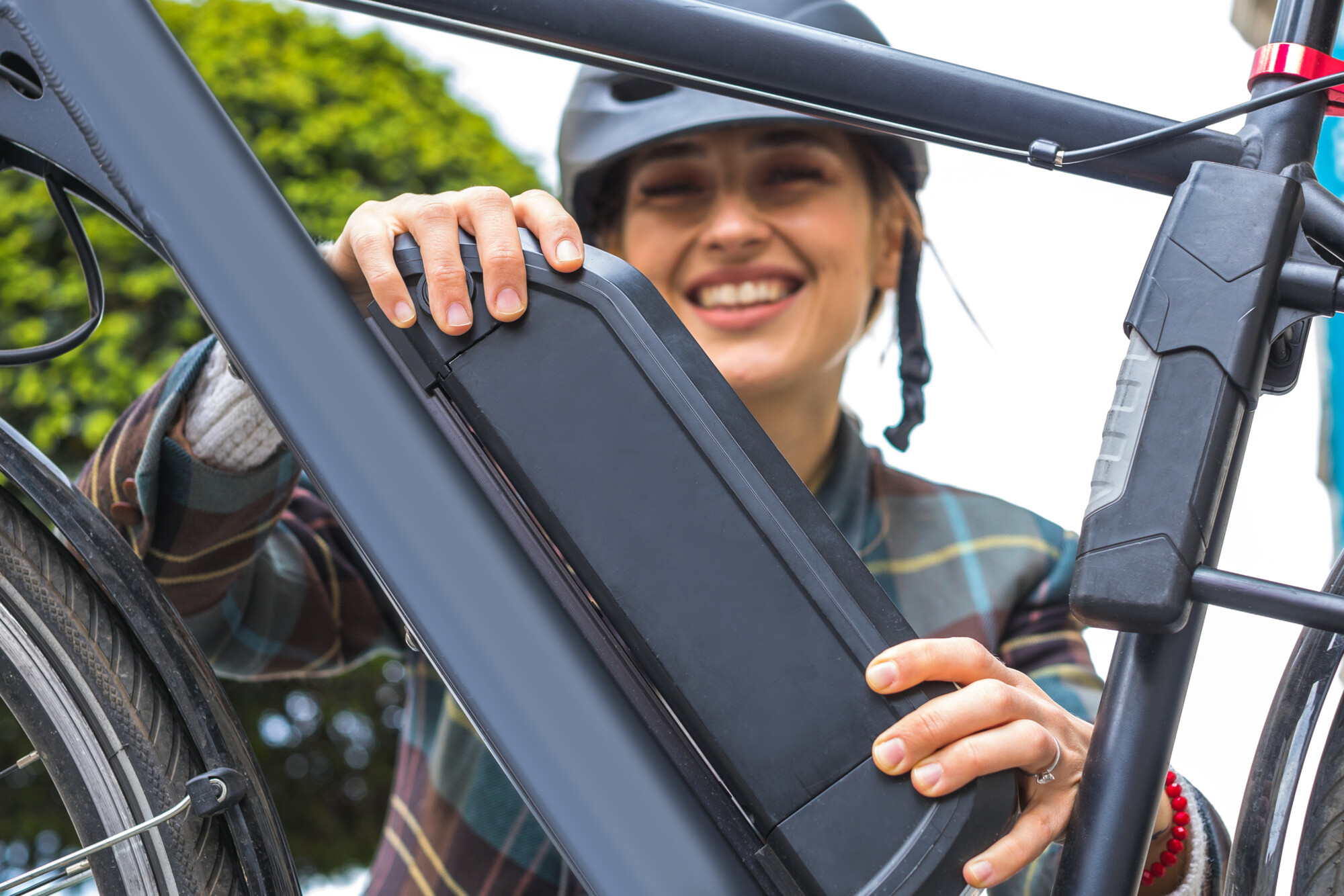 Woman holding an electric bike battery mounted on frame