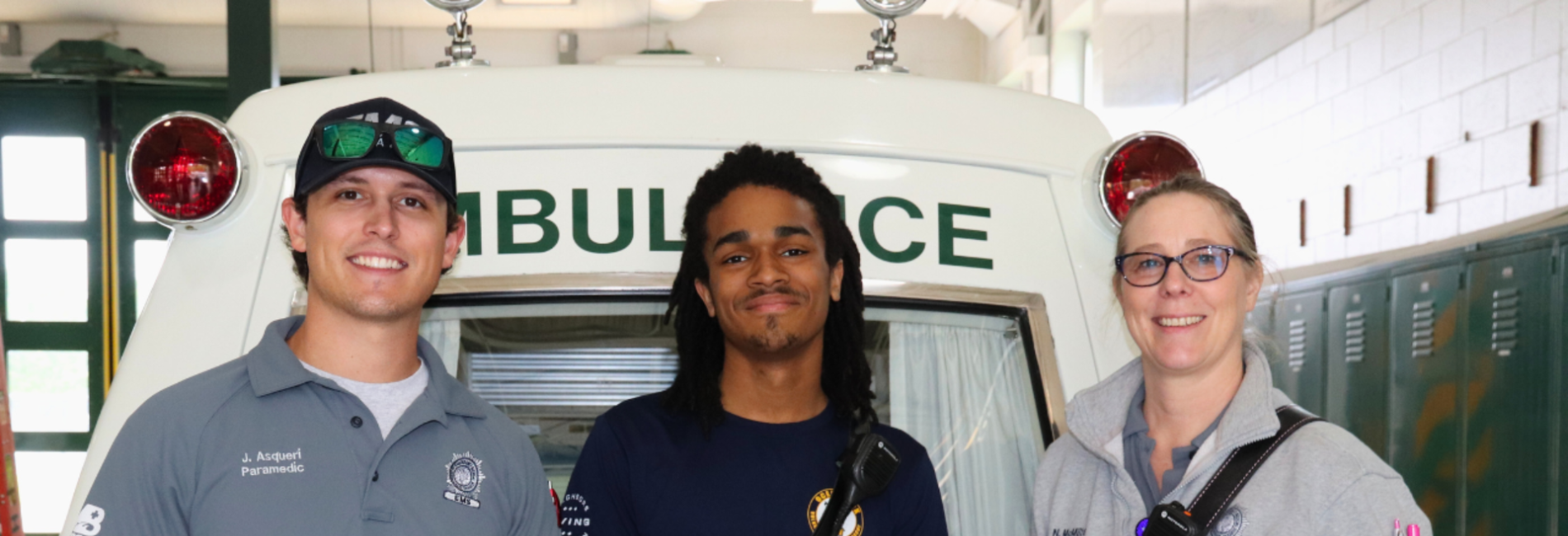 EMS volunteers in front of ambluance inside station