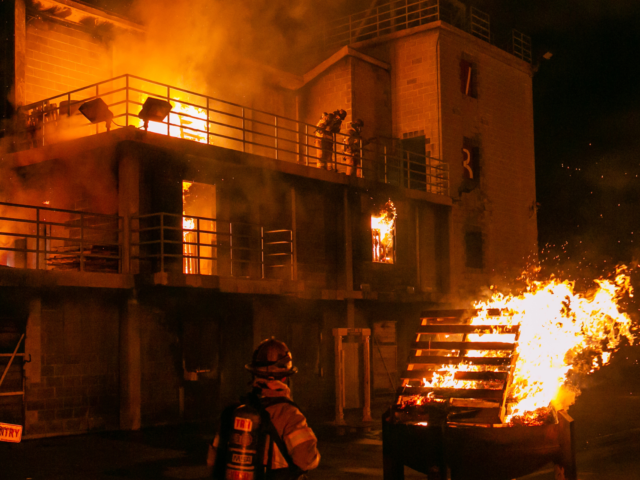 Fire training center burn training building on fire at night