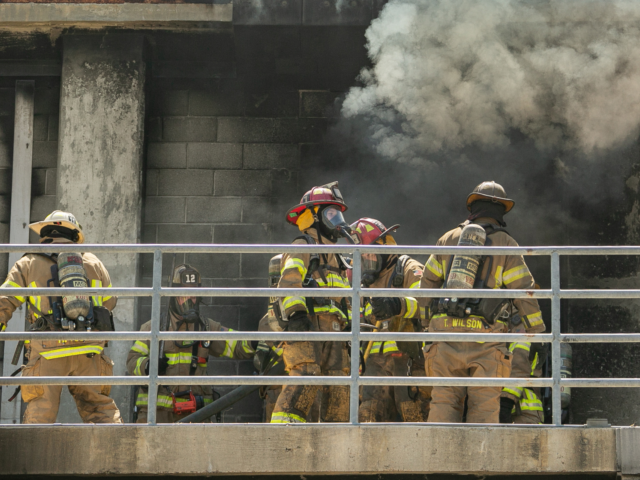 Firefighters preparing to enter a burning building for training exercise