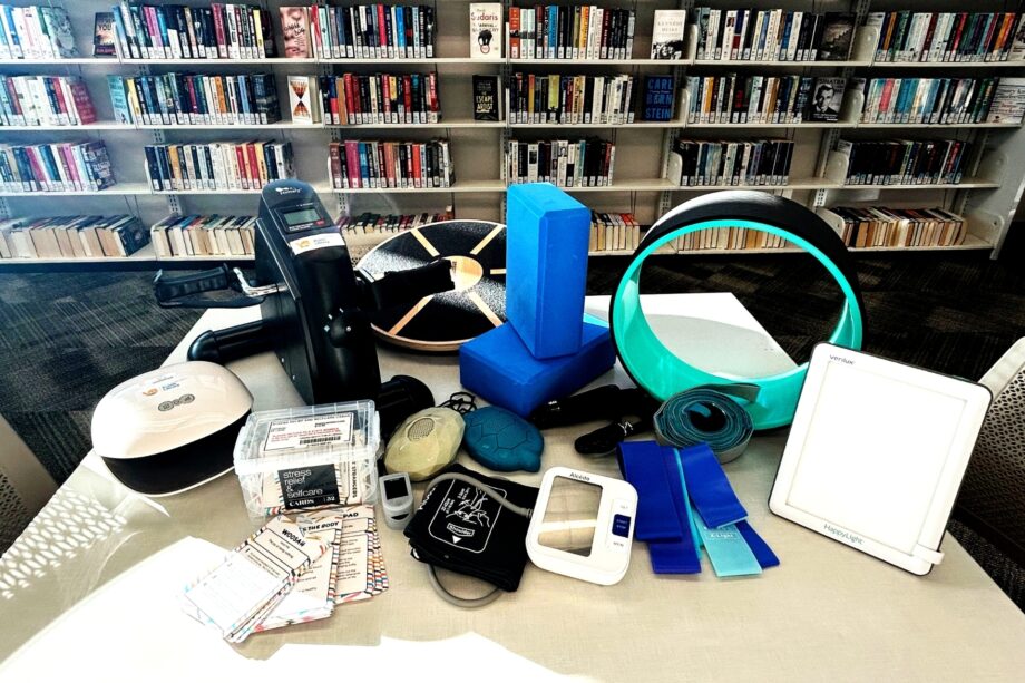 Fitnes gear on a library table with books on library shelves behind them