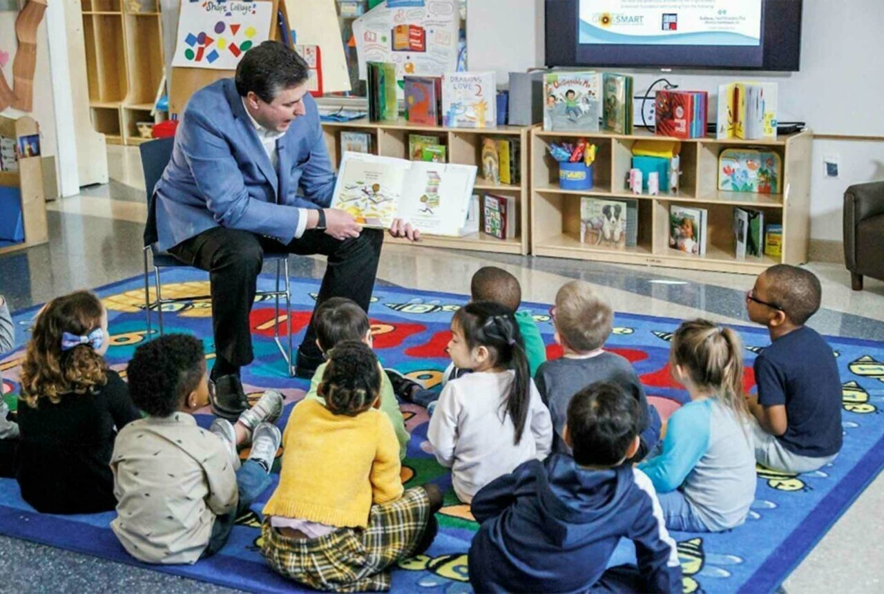 Person reading to a group of children