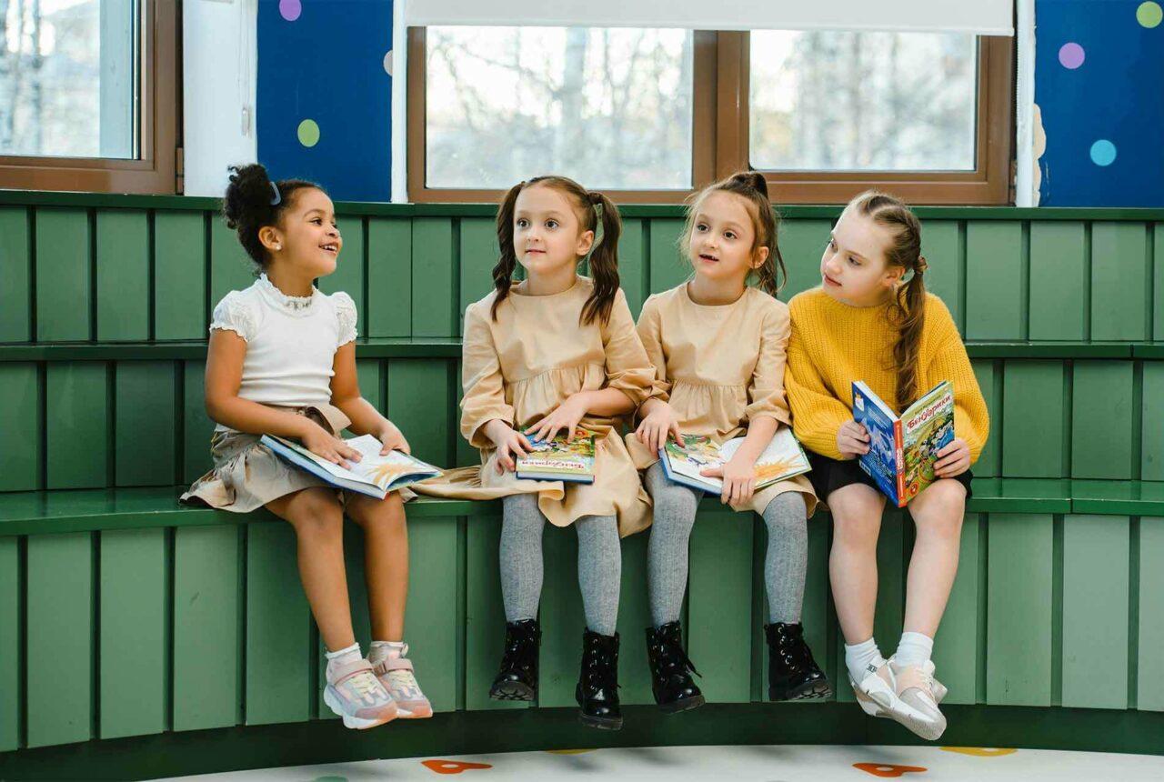 Children sitting on bench reading