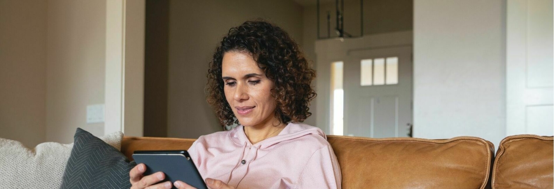 Woman reading Kindle sitting on couch