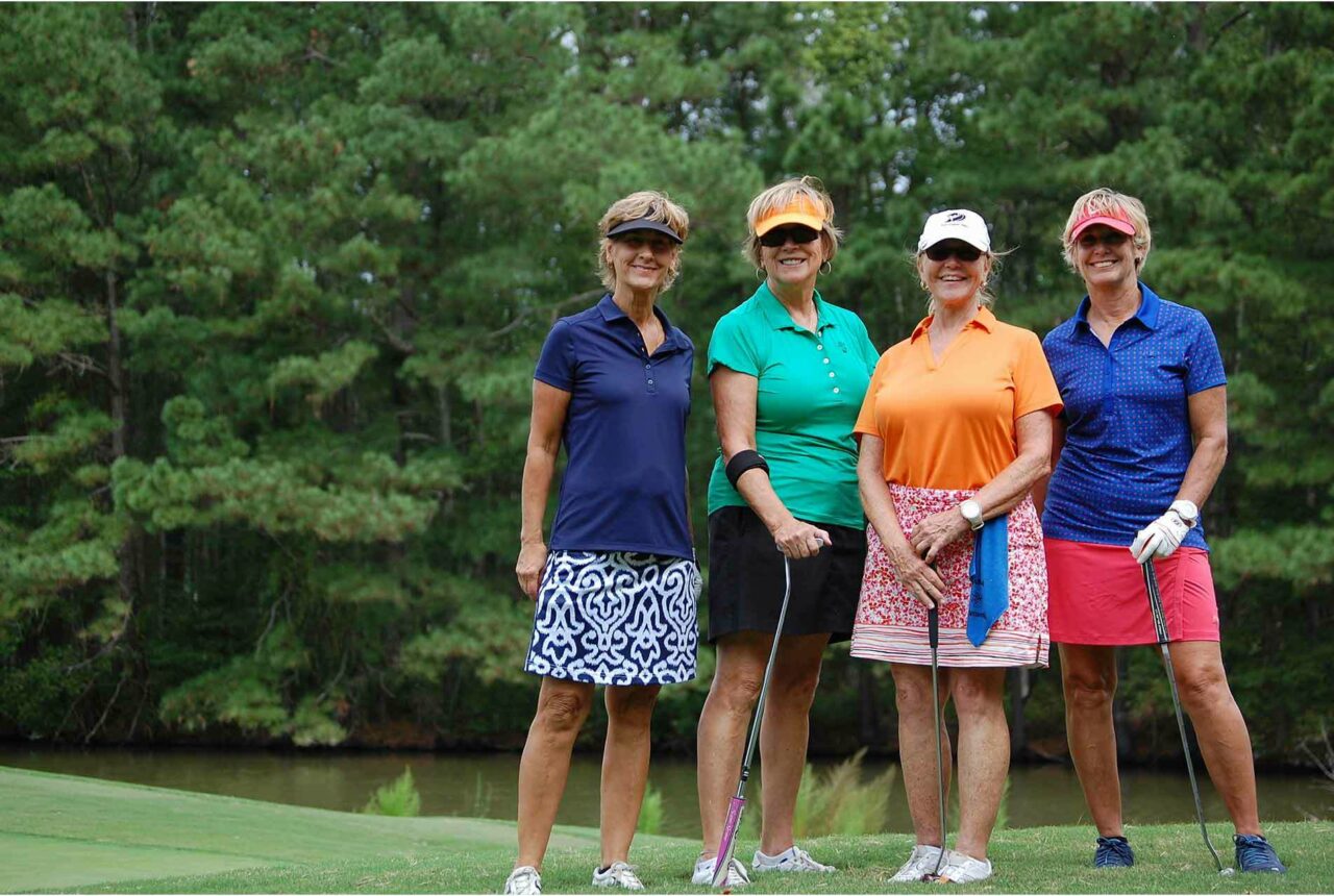 Women posing for pictures in a golf course