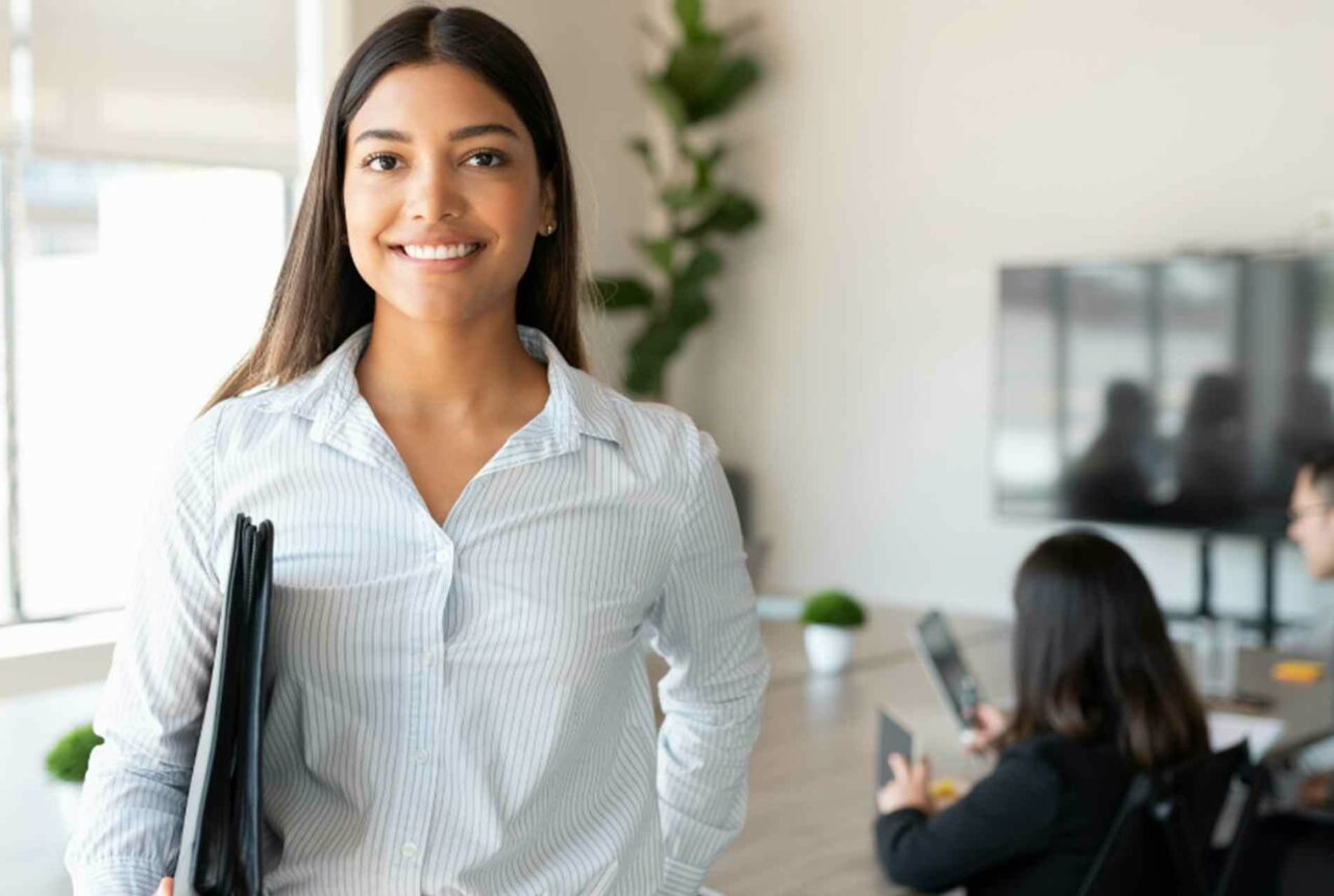 Business woman holding a binder in a conference room