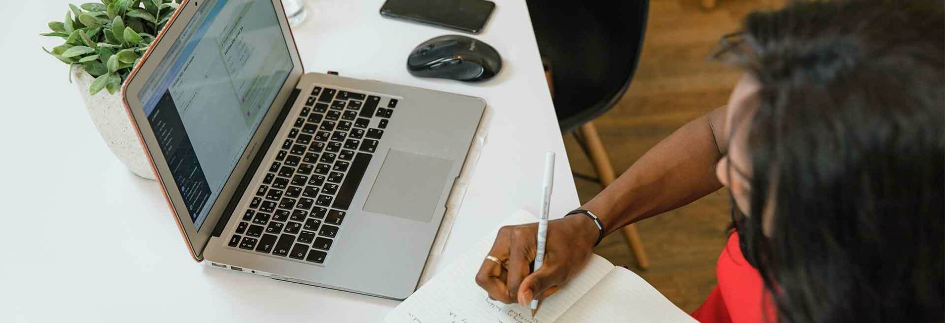 Woman taking notes from a laptop