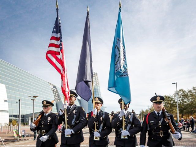 Police honor guard carrying U S State of Virginia and City of VB flags in parade