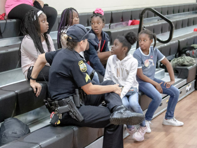 Police officer talking to a group of young students at school event