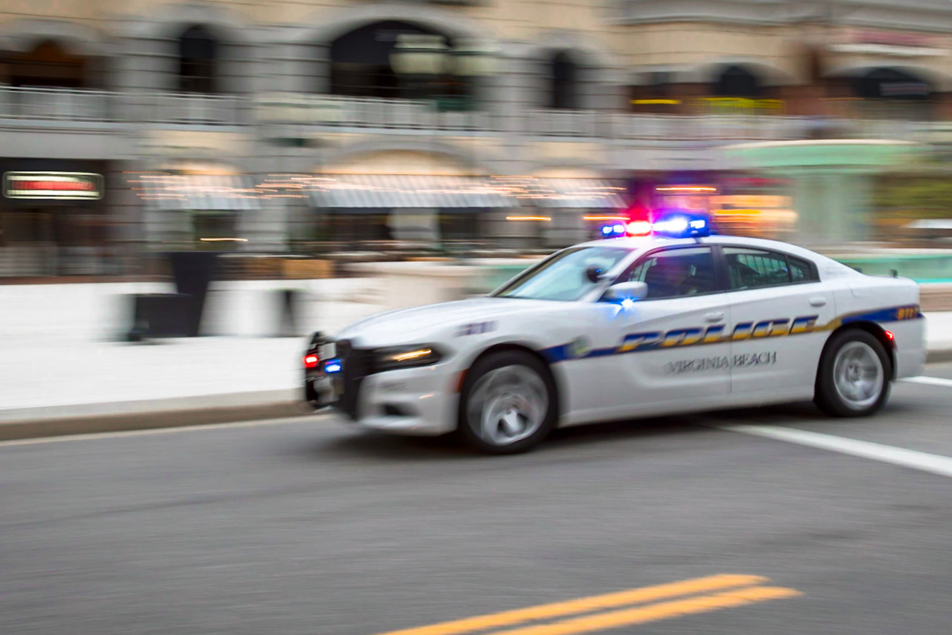 Police car with lights on driving through Town Center alt 2