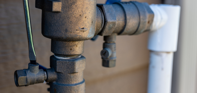Backflow preventer pipe outside a home connected to pipes