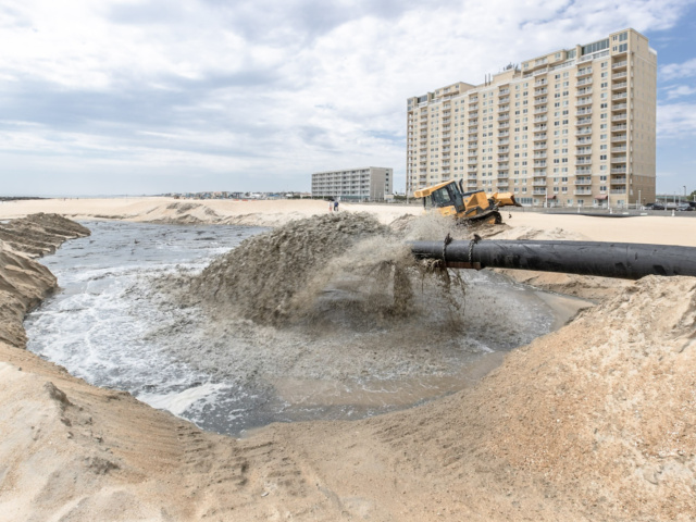 Pipe depositing dredge sand onto beach