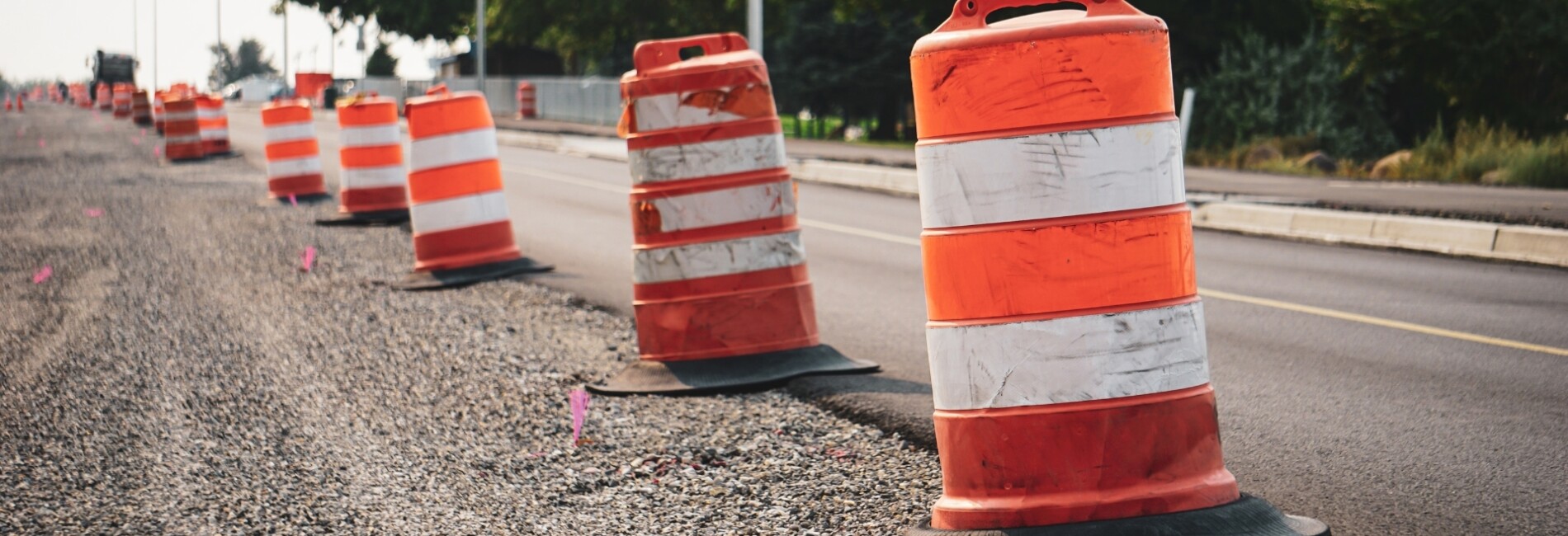 Traffic barrels marking unpaved portion of road