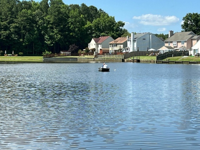 Survey crew on a boat collecting samples in Holland Pines pond